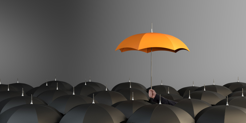 An orange umbrella in between in the black umbrella